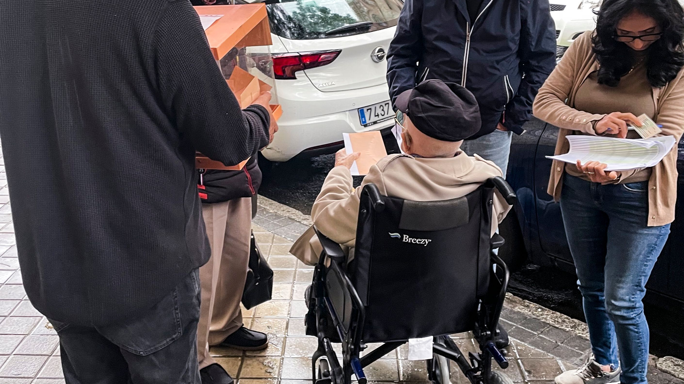 Los miembros de una mesa electoral del instituto Santa Engracia de Madrid han sacado este domingo una urna a la calle para facilitar que un anciano en silla de ruedas pudiera votar