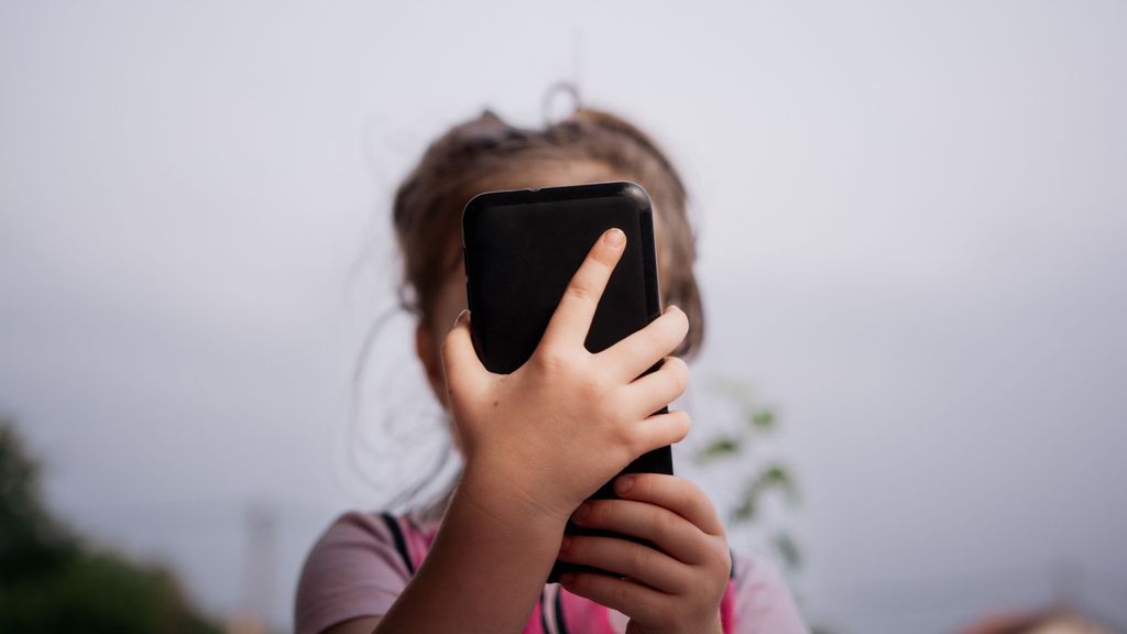 Una niña utiliza un teléfono móvil