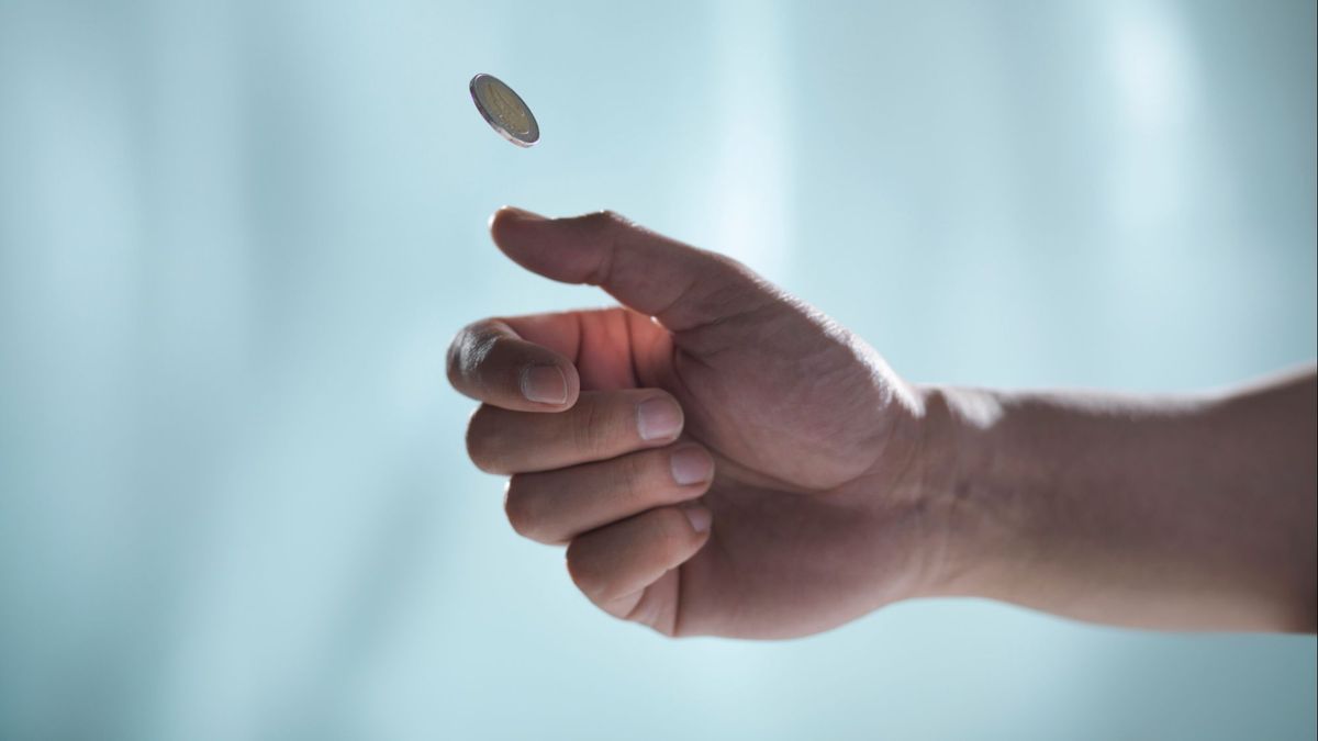 Un hombre lanza una moneda al aire para determinar la suerte