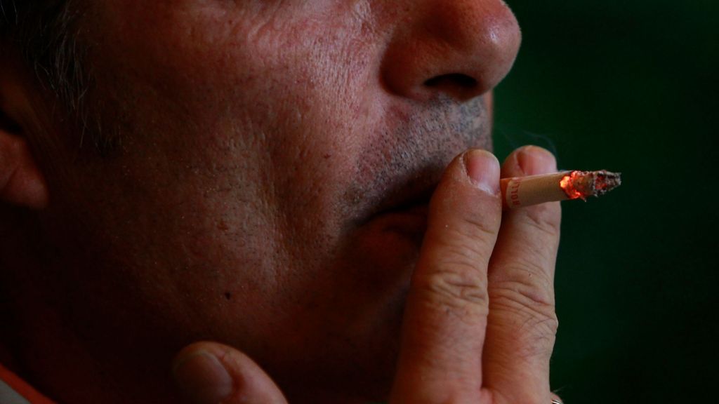Un hombre fuma un cigarrillo