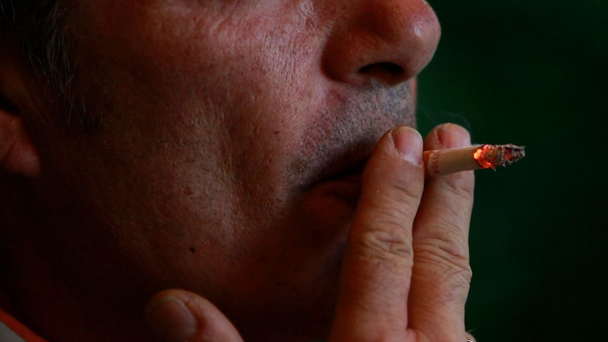 Un hombre fuma un cigarrillo Un hombre fuma un cigarrillo