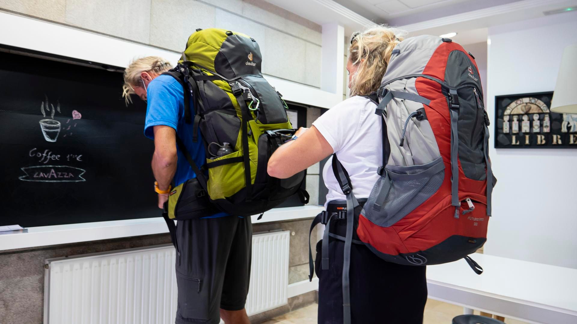 Archivo - Una peregrina busca su documentación en una mochila para acceder a un albergue, en Santiago de Compostela, a 9 de octubre de 2021, en Santiago de Compostela