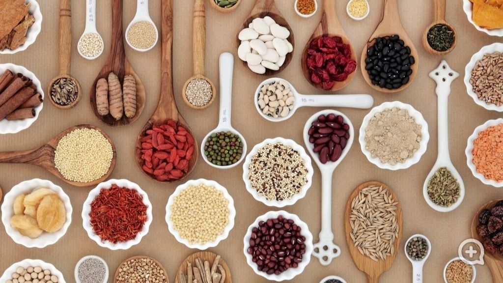 Large superfood sampler for good health in spoons and bowl forming an abstract background. Highly nutritious in antioxidants, vitamins, minerals and dietary fiber.