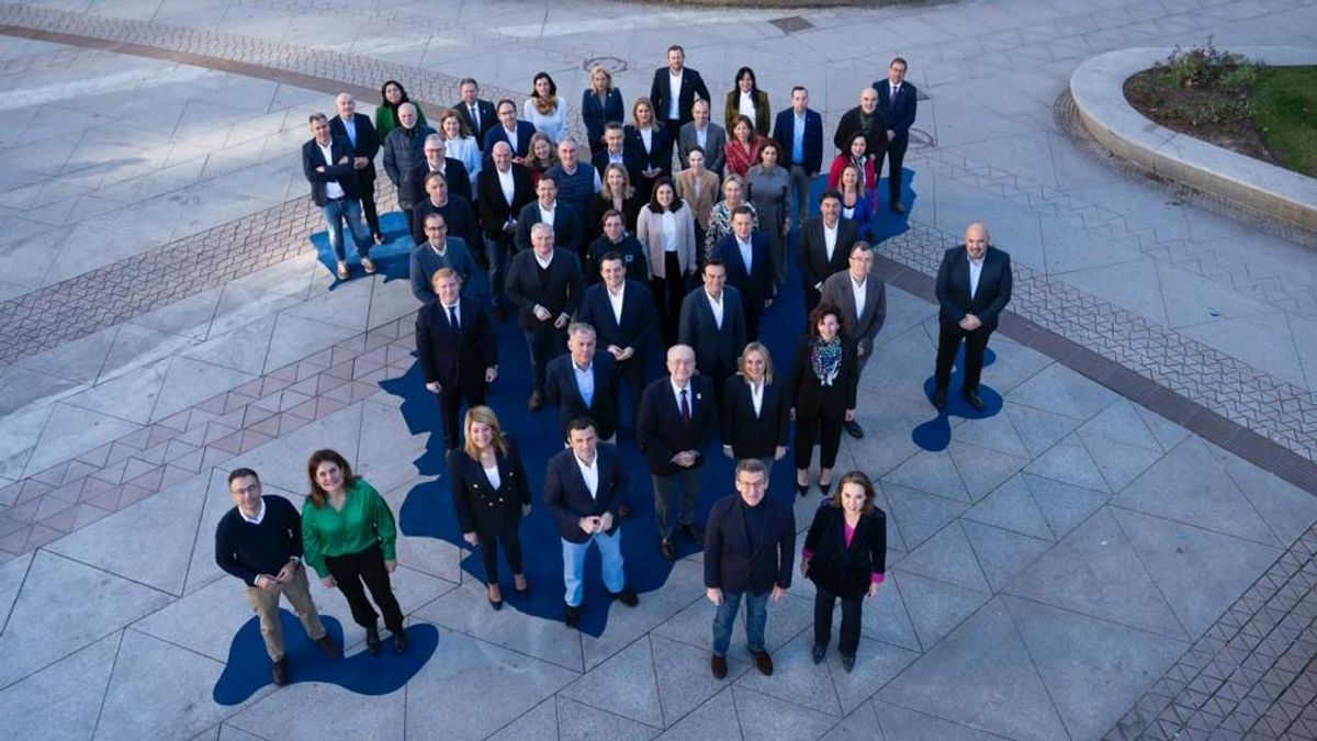 Feijóo posa con sus candidatos municipales sobre un mapa azul de España