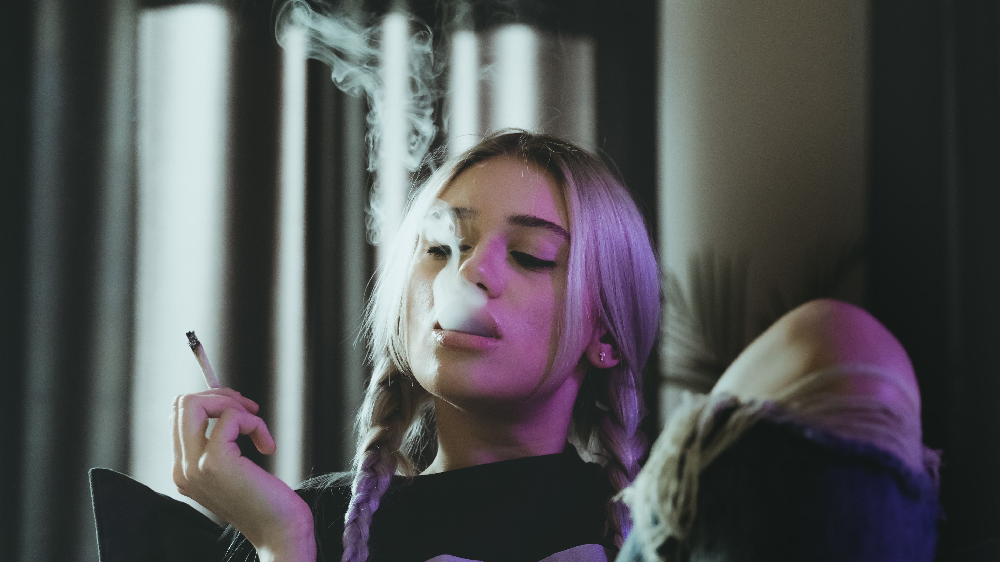 Una joven fumando un porro de marihuana