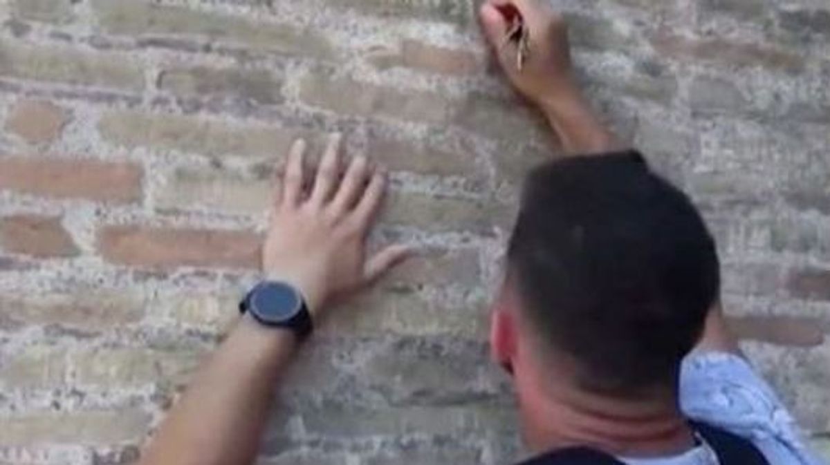 Turista grabando su nombre en una pared de casi 2.000 años en el Coliseo de Roma