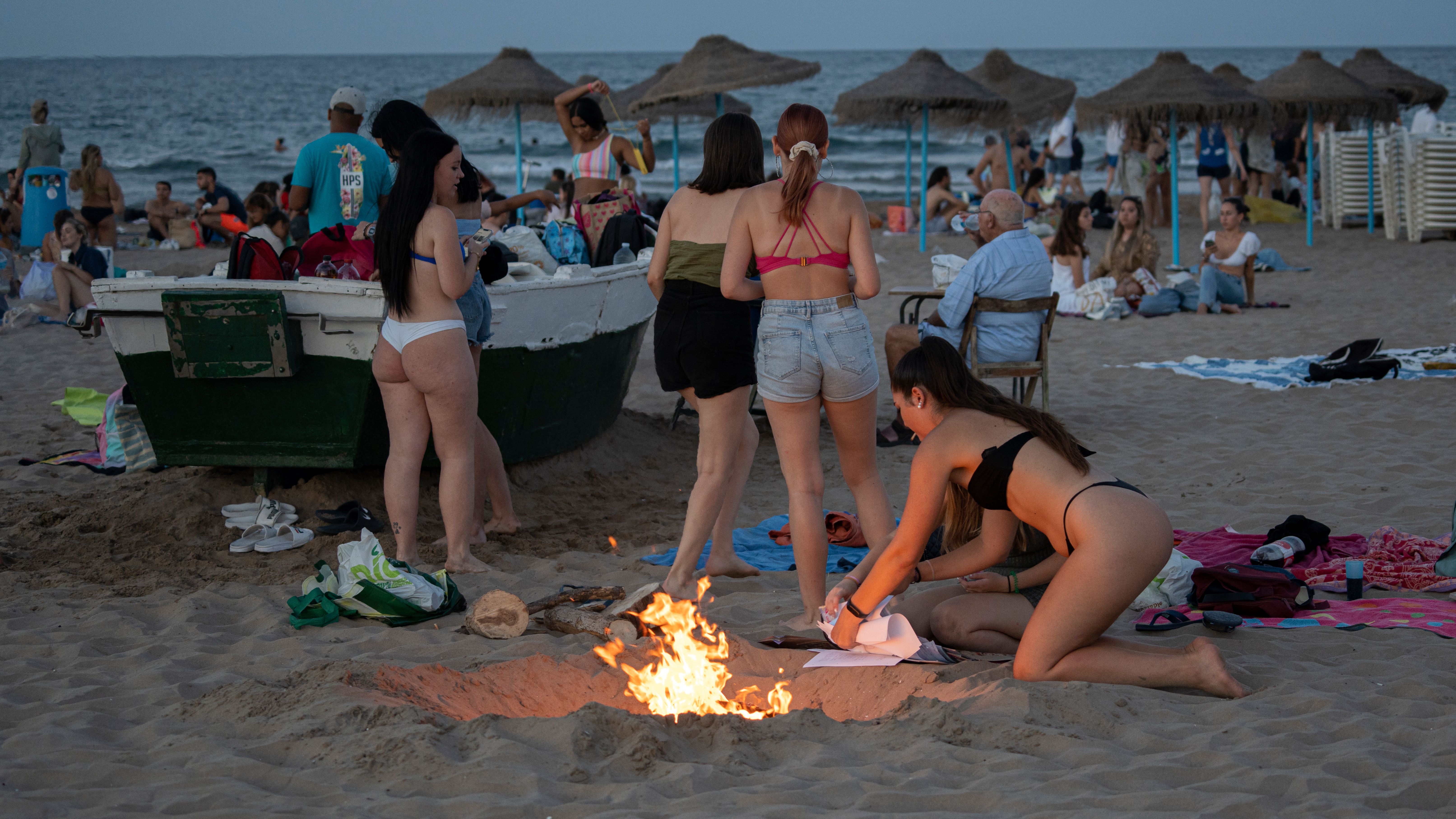 Un grupo de jóvenes se divierten en la playa de la Malvarrosa, en Valencia durante las hogueras de la noche de San Juan