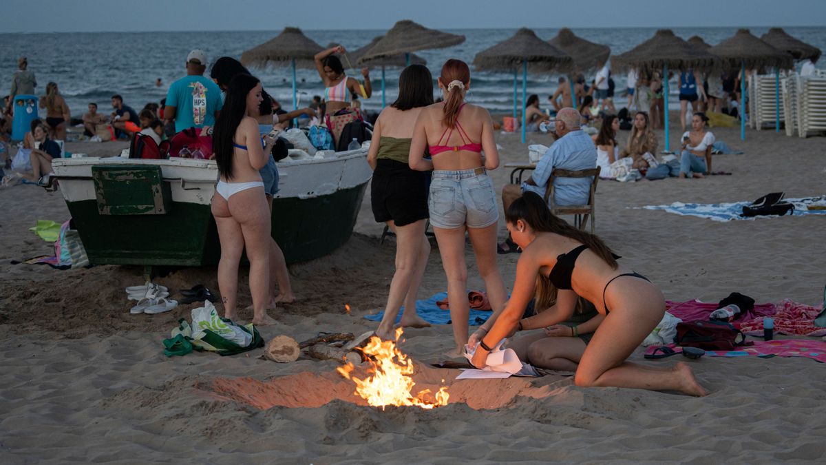 Un grupo de jóvenes se divierten en la playa de la Malvarrosa, en Valencia durante las hogueras de la noche de San Juan