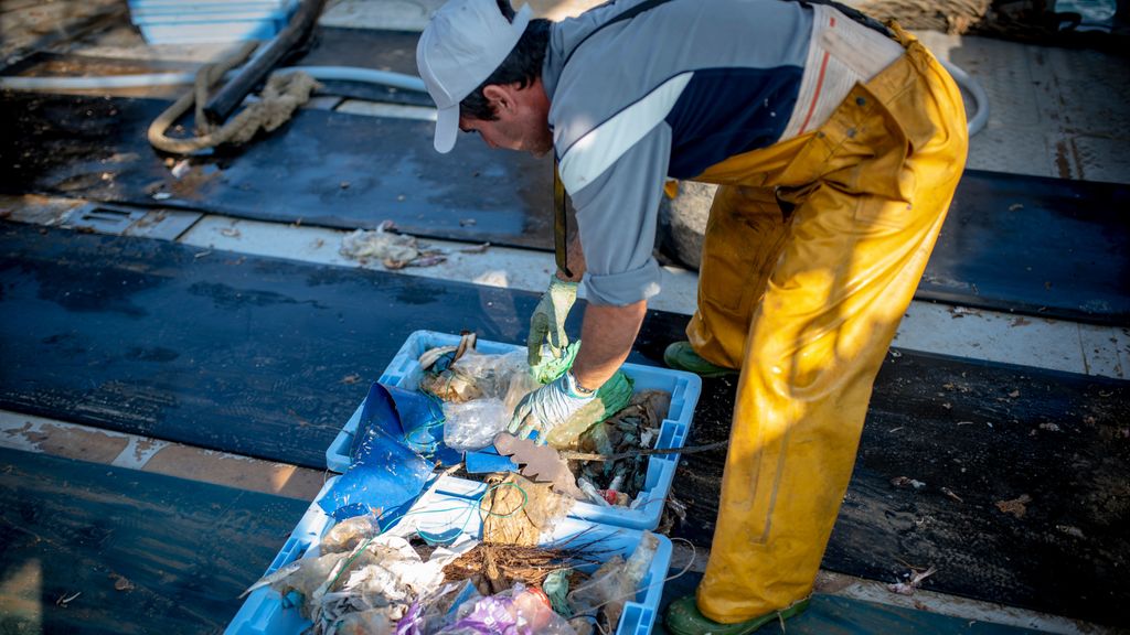 Un pescador con basura que ha recogido del fondo marino