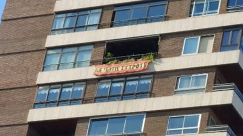 Pancarta con el lema 'Que te vote Txapote' en la terraza de un piso de Madrid