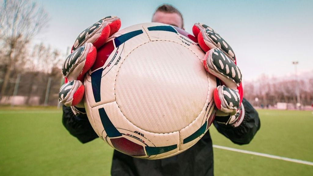 Un portero posa con un balón en las manos