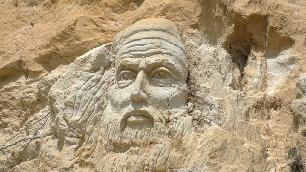 Aparece una misteriosa cara esculpida sobre el acantilado de la playa del Rompeculos de Huelva