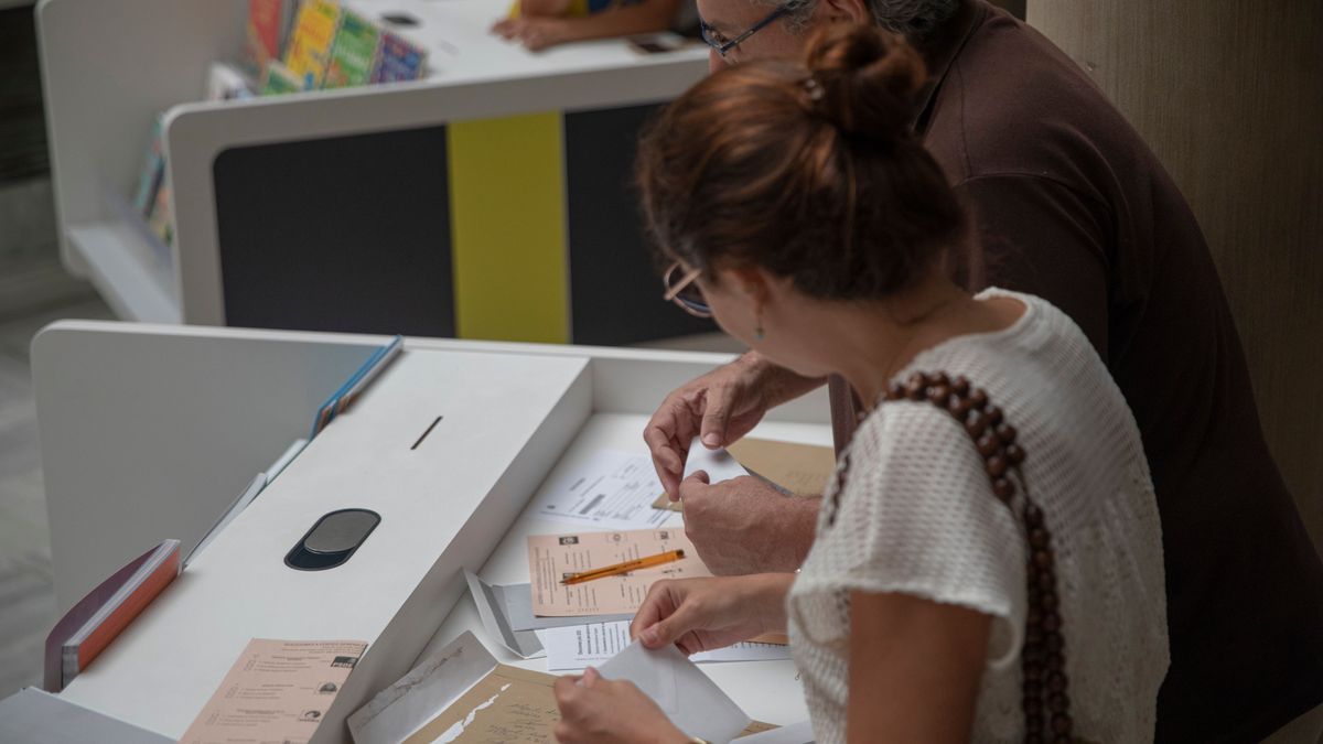 Dos personas cumplimentan el voto por correo