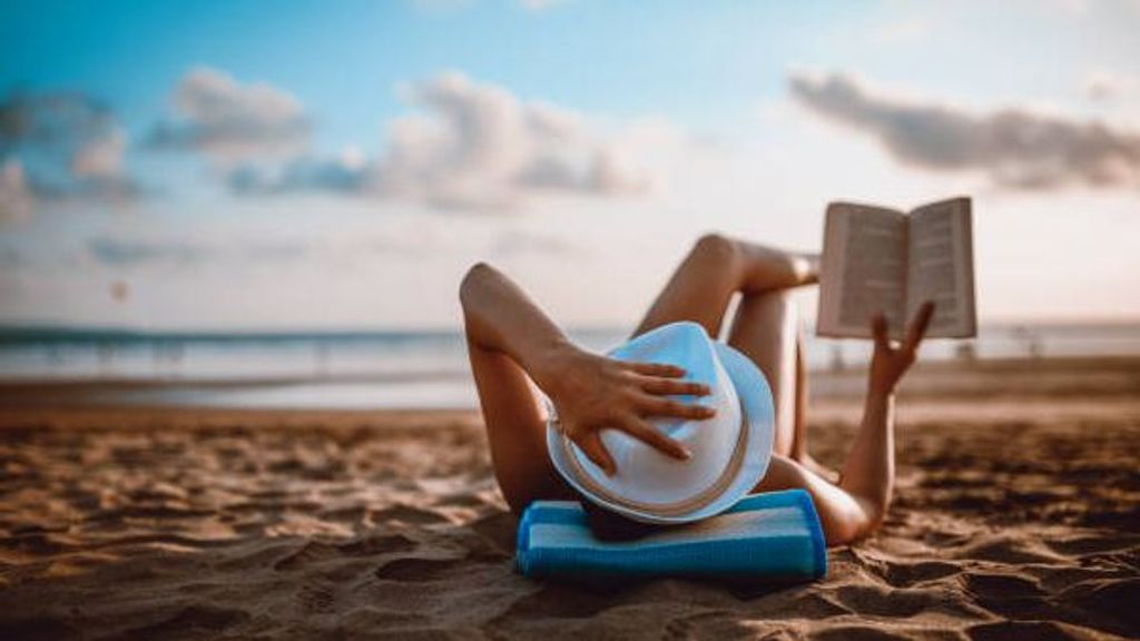 Mujer toma el sol en la playa.