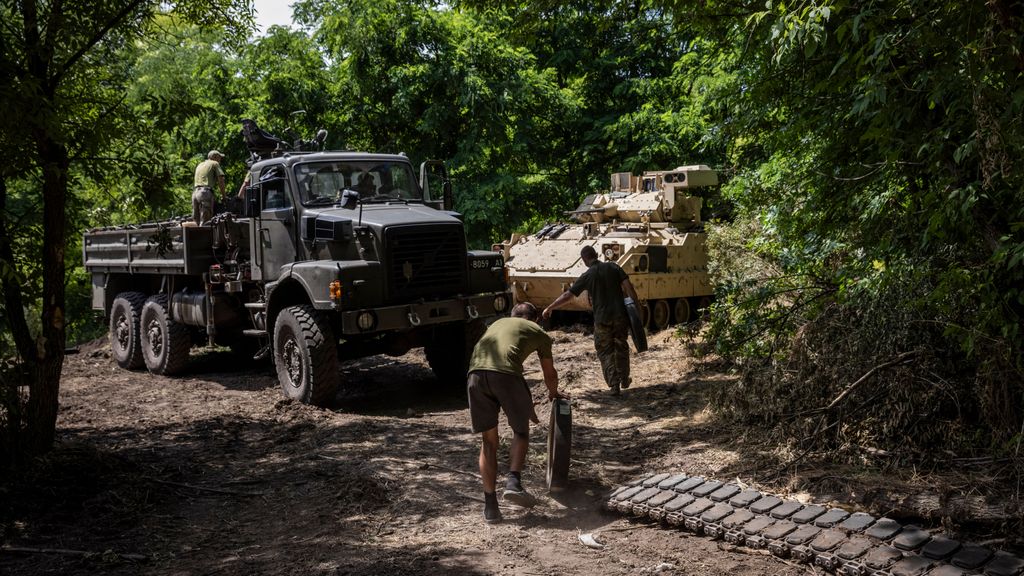 Soldados cambian las ruedas un vehículo de combate Bradley dañado por minas y artillería en Zaporiyia (Ucrania).
