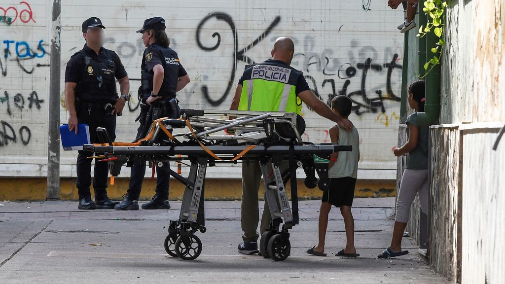 Miembros de la Policía Nacional acompañan a los hijos de una joven asesinada esta tarde en el barrio de Pescadería de Almería,