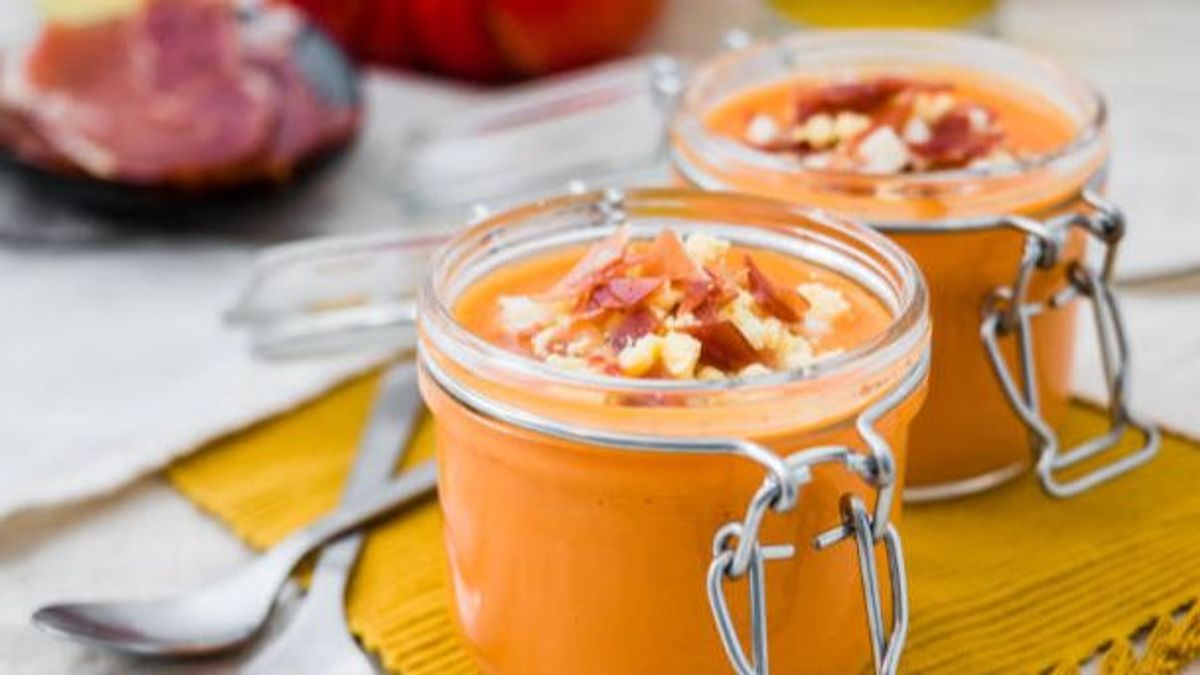 Organic Salmorejo. A bowl of spanish tomato cream soup. In a jar with ingredients in the background.
