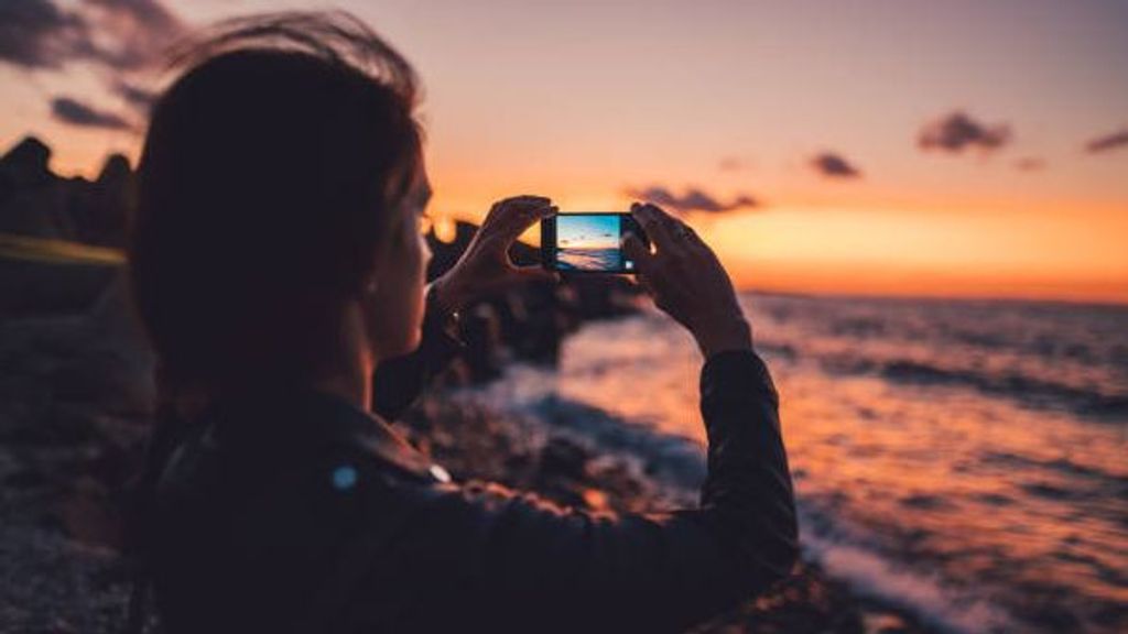 Chica saca una foto del paisaje.