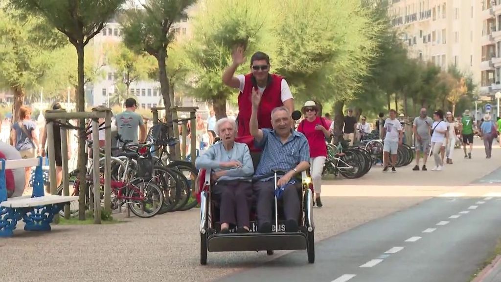 Un grupo de voluntarios pasea a ancianos de residencias de San Sebastián en triciclos