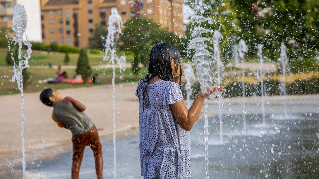 Unos niños se refrescan este viernes durante la tercera ola de calor