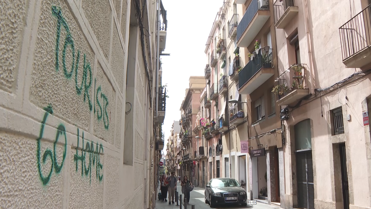 Tres turistas buscan su alojamiento en el barrio de Gràcia, en Barcelona