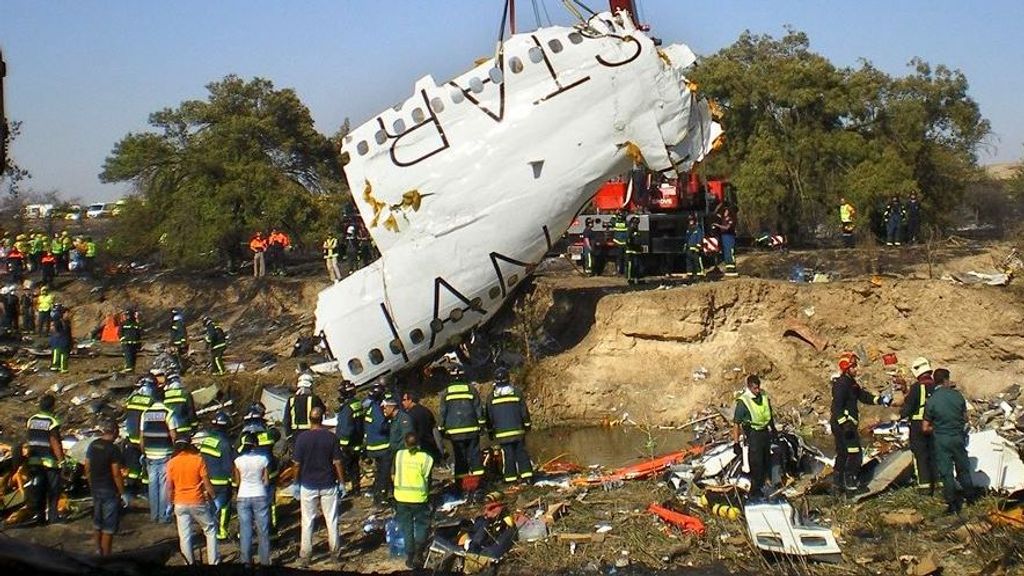 Bomberos y agentes de la Guardia Civil inspeccionan el lugar del accidente, el 20 de agosto de 2008