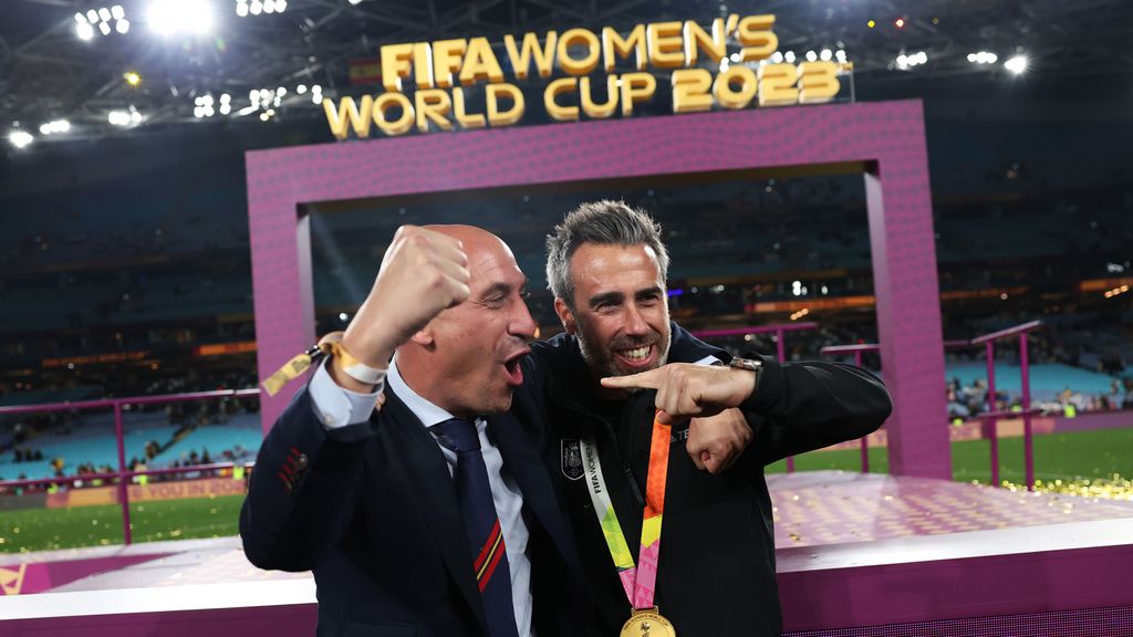 El los tiene más grandes. Presi y entrenador (que dijo "somos campeones", en masculino, en su primera declaración) posan delante del cartel que dice Copa del Mundo de Mujeres..