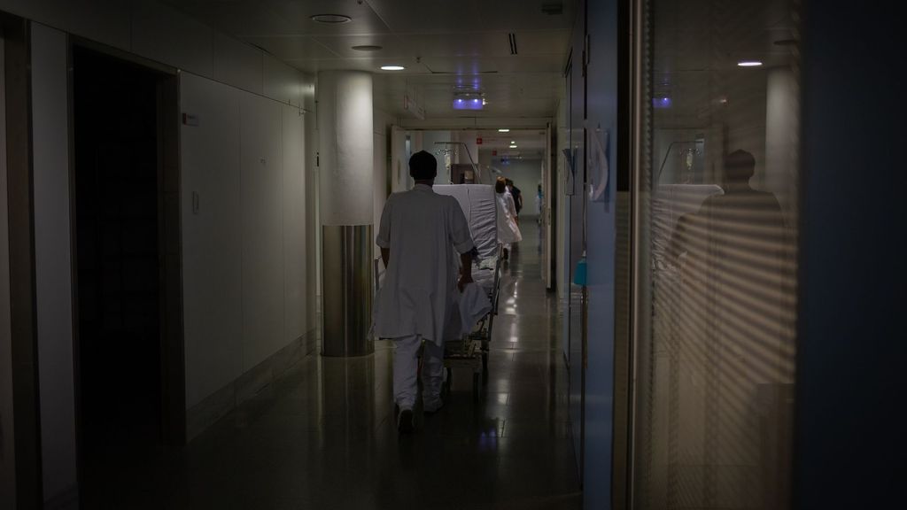Profesional sanitario traslada una cama móvil en la UCI del Hospital de la Santa Creu i Sant Pau