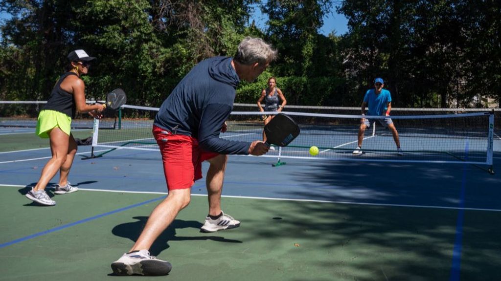 Cuatro personas disputan un partido de pickleball