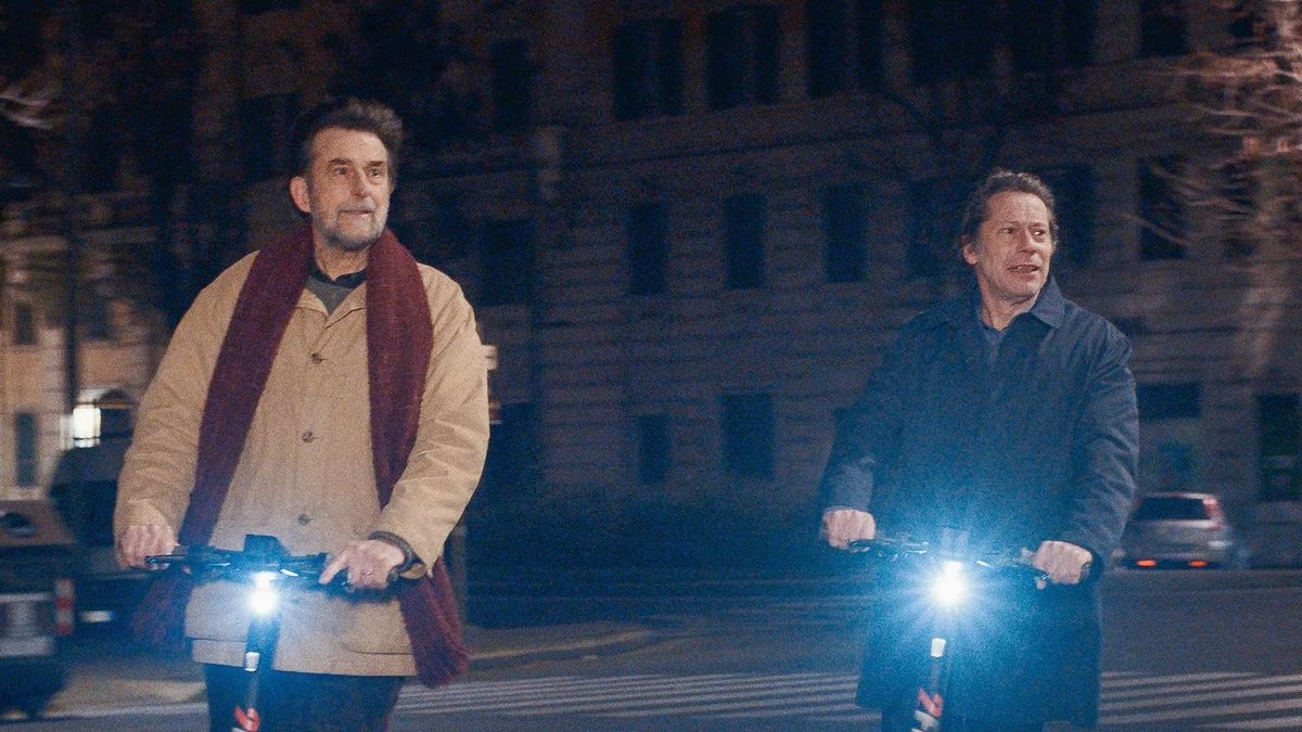 Nanni Moretti y Mathieu Amalric paseando por Roma. Tres décadas después de 'Caro diario' el director italiano cambia la vespa por el patinete eléctrico.