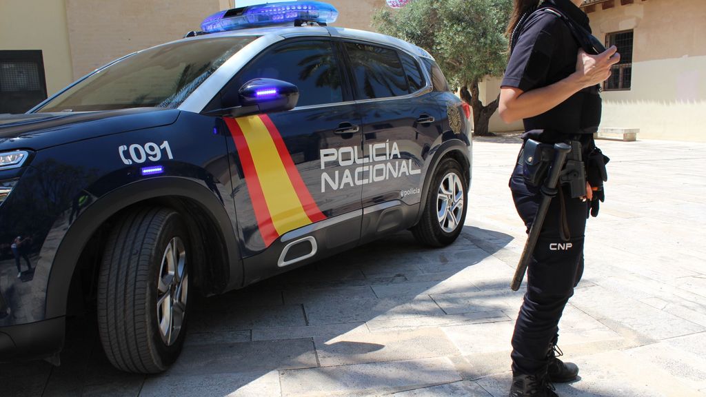 imagen de archivo de una agente junto a un vehículo policial.