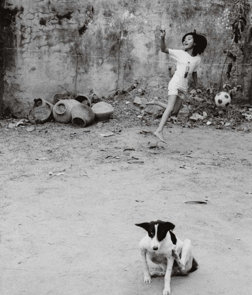 Niño jugando a futbol en Birmania ante la presencia pasiva de un perro. Foto de la colección 'The Oval' impresa en gelatina de plata. Edición limitada