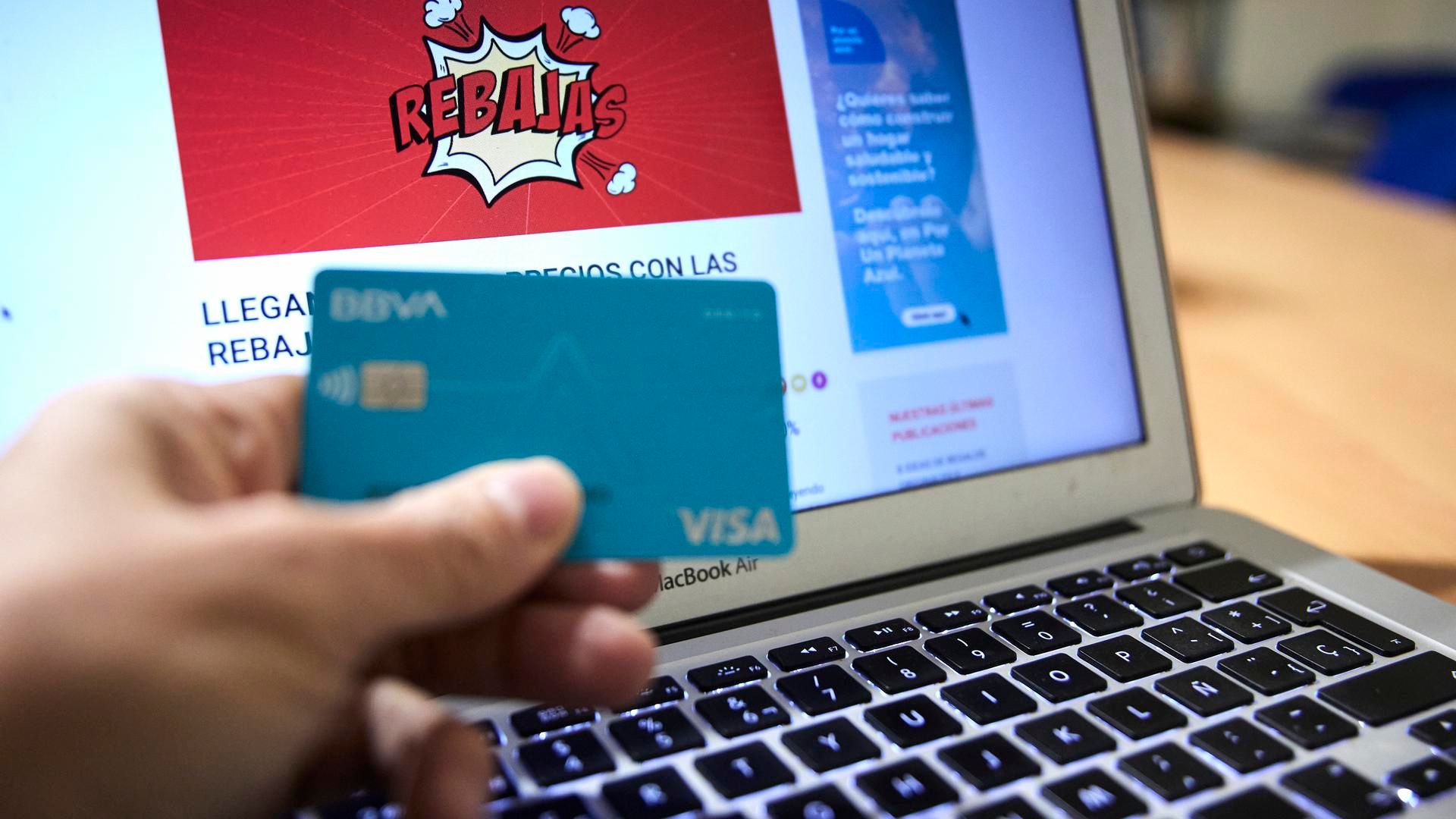 Archivo - Una persona compra con su tarjeta de crédito