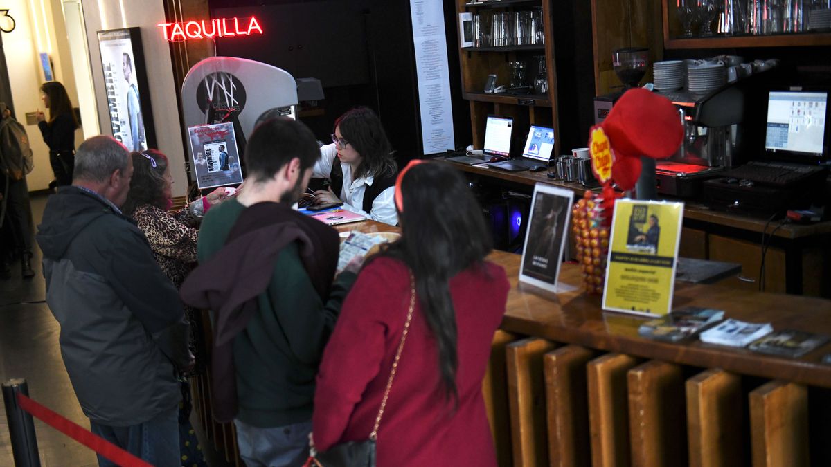 Varias personas esperan para comprar una entrada de cine en una taquilla