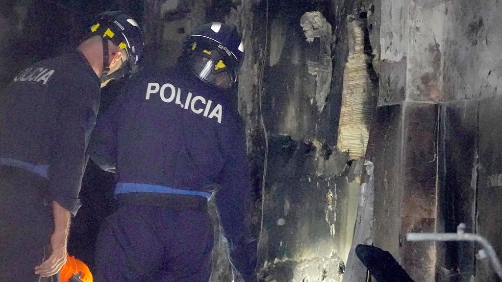 Dos agentes de la policía trabajan en el edificio calcinado