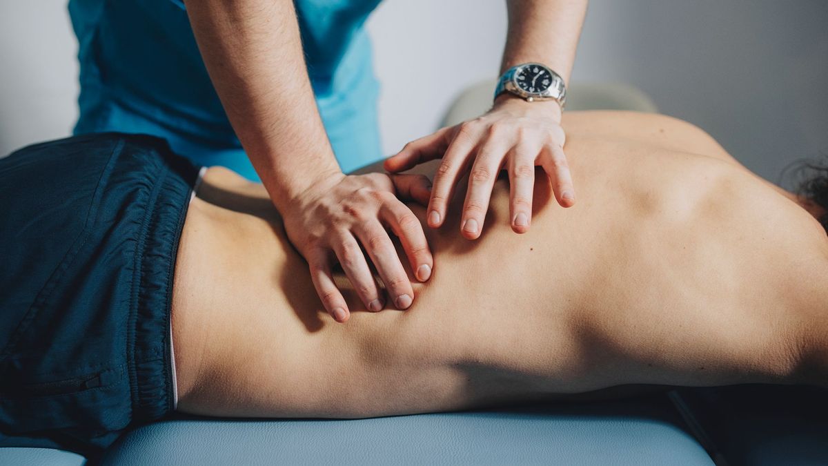 Un paciente recibe traatamiento de un fisioterapeuta