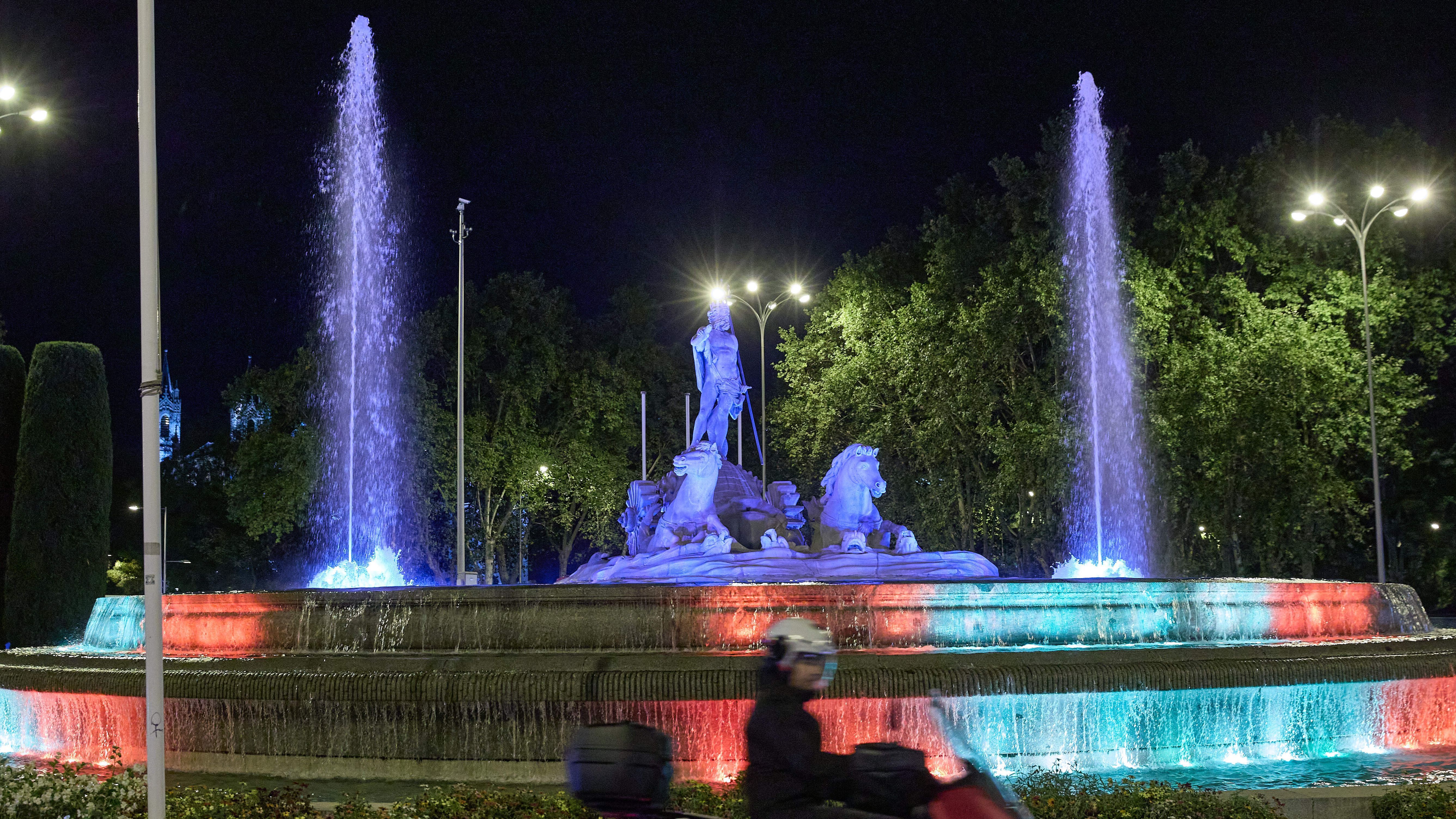 La fuente de Neptuno iluminada con los colores de la bandera nacional el día previo a la jura de la Constitución de la Princesa, a 30 de octubre de 2023