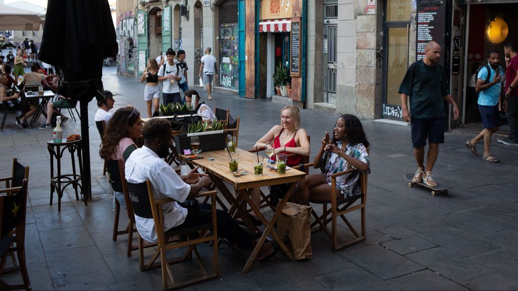 Varias personas sentadas en bares en Barcelona