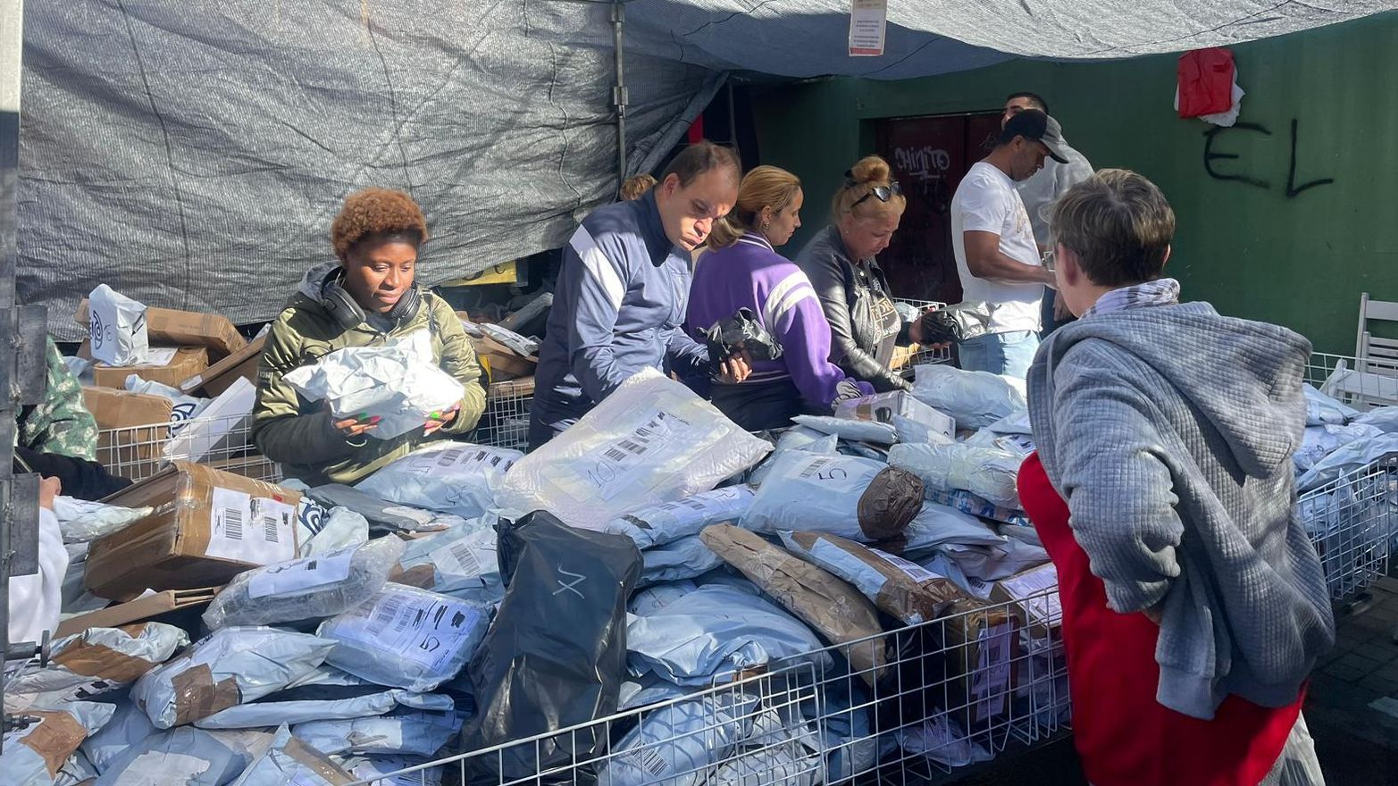Los clientes se arremolinan en la parada para tocar los paquetes