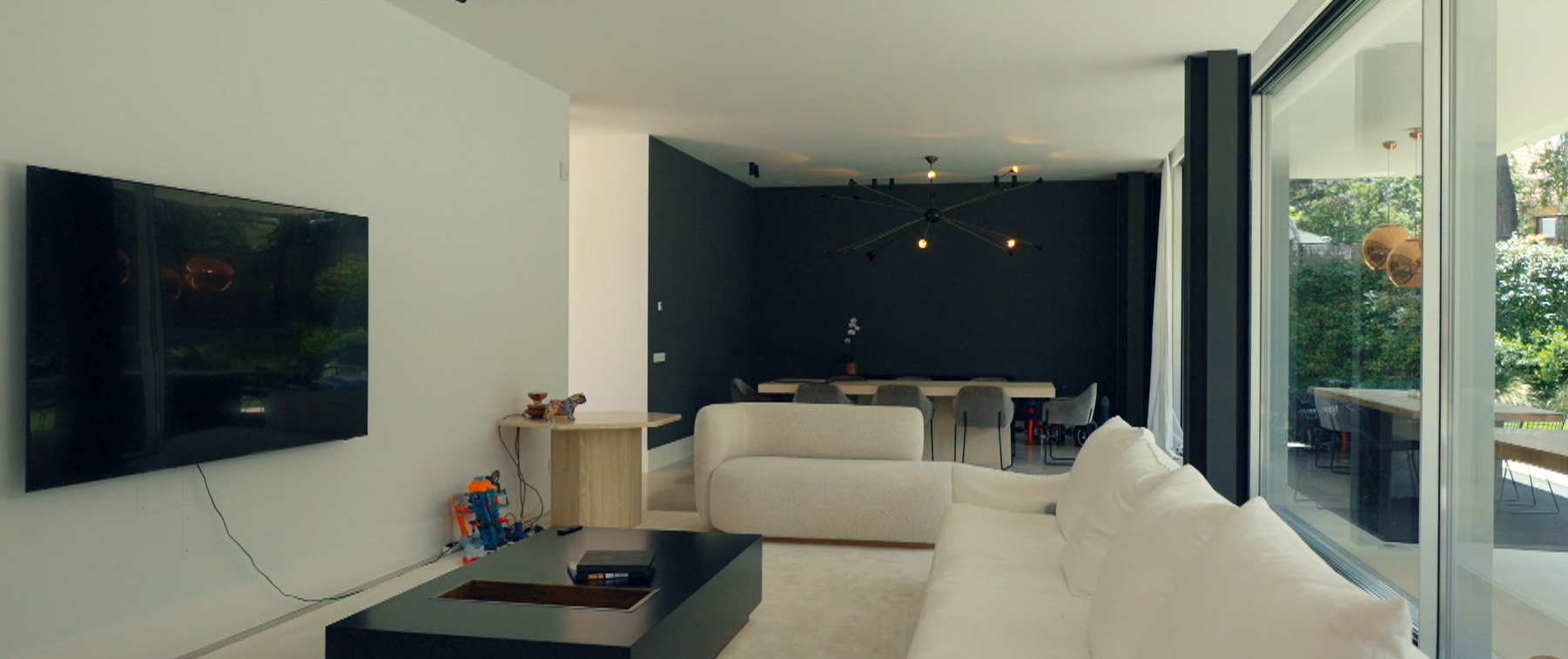 Una de las salas de estar, con pared acristalada y vistas al jardín