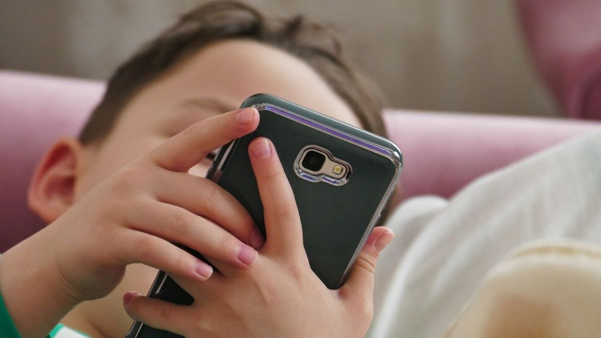 Un niño usando un teléfono móvil