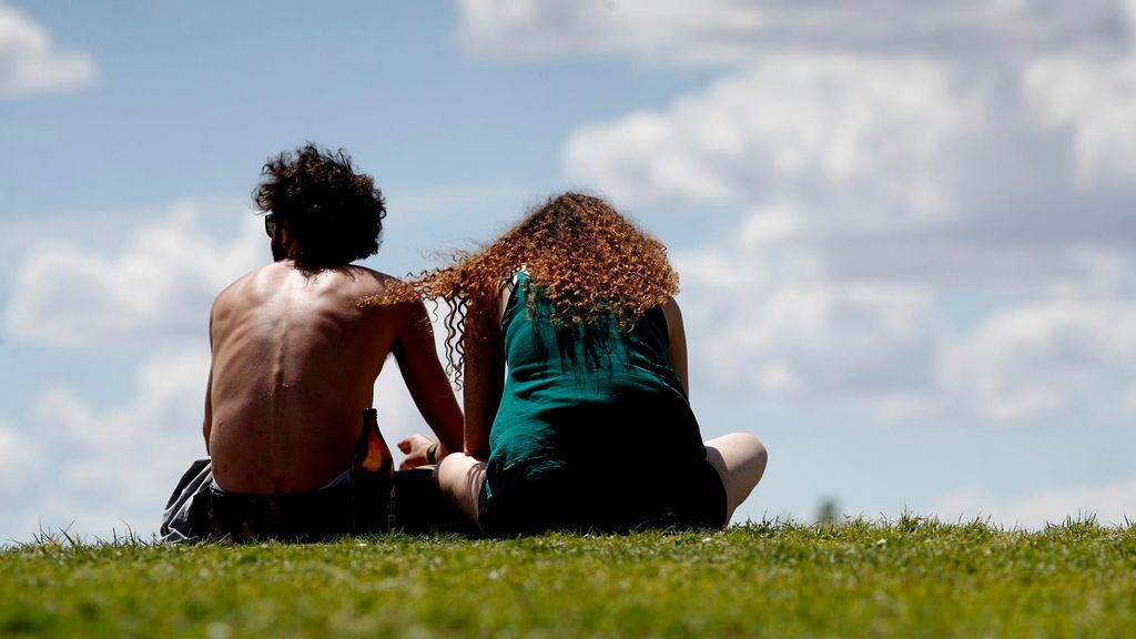 Archivo - Una pareja de jóvenes disfruta de un soleado día sentados en el césped