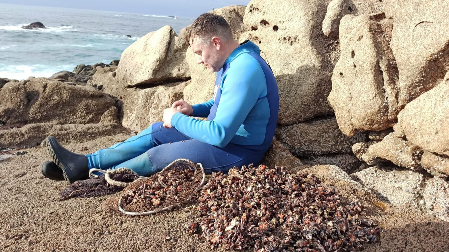 Un percebeiro revisa sus capturas después de una jornada de trabajo