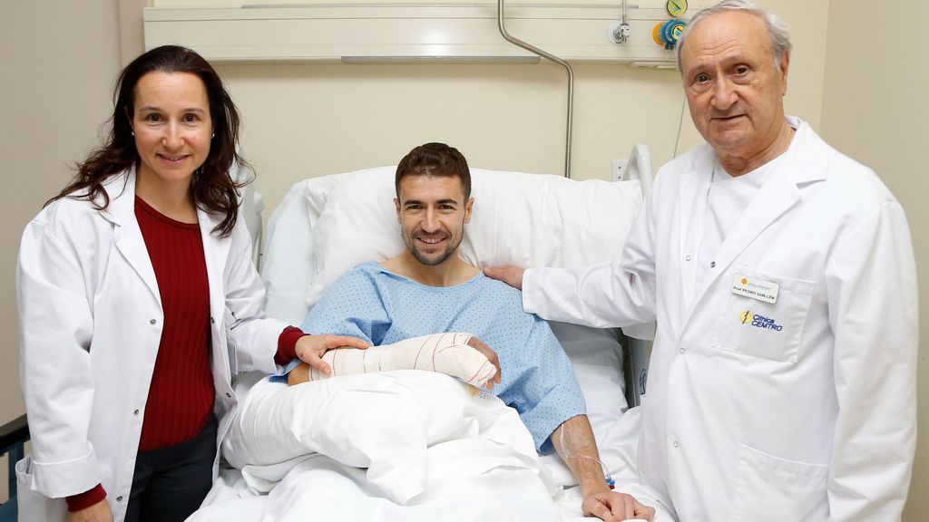 Pedro Guillén posa con Gabi, ex jugador del Atlético, tras operarle junto a una de sus hijas