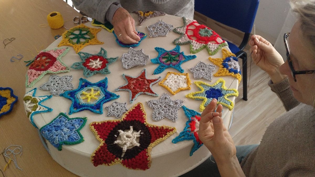 Dos vecinas fabricando a mano originales guirnaldas navideñas