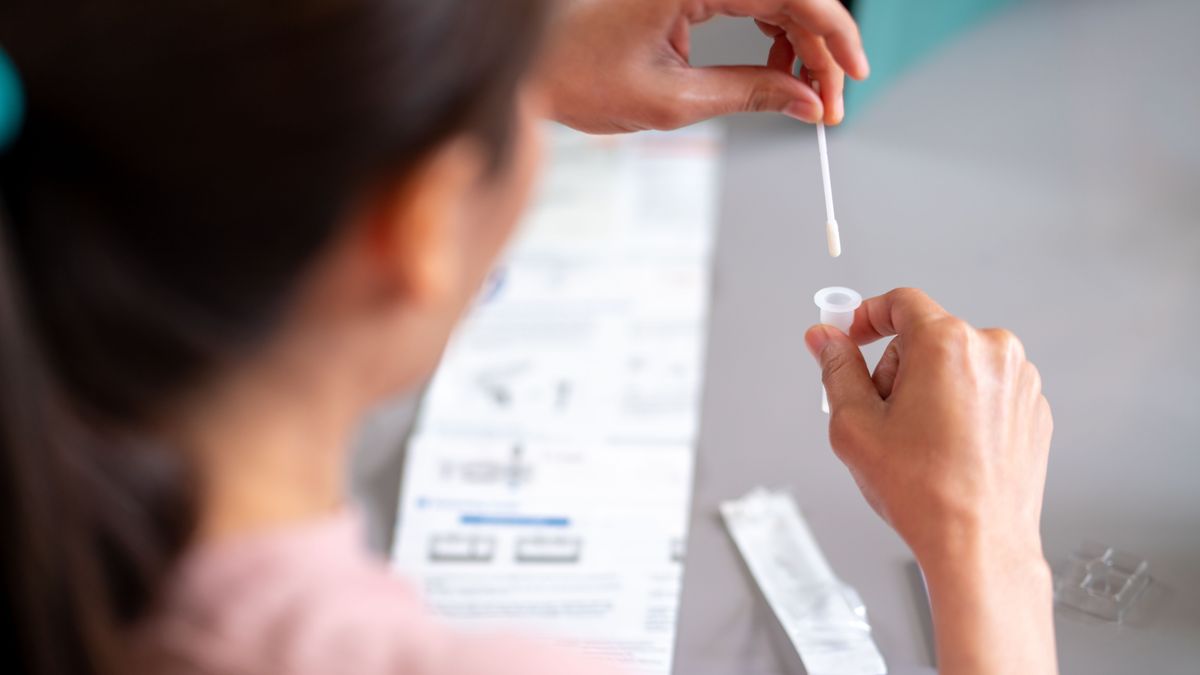 Una mujer se hace un test para detectar si tiene covid-19 o gripe