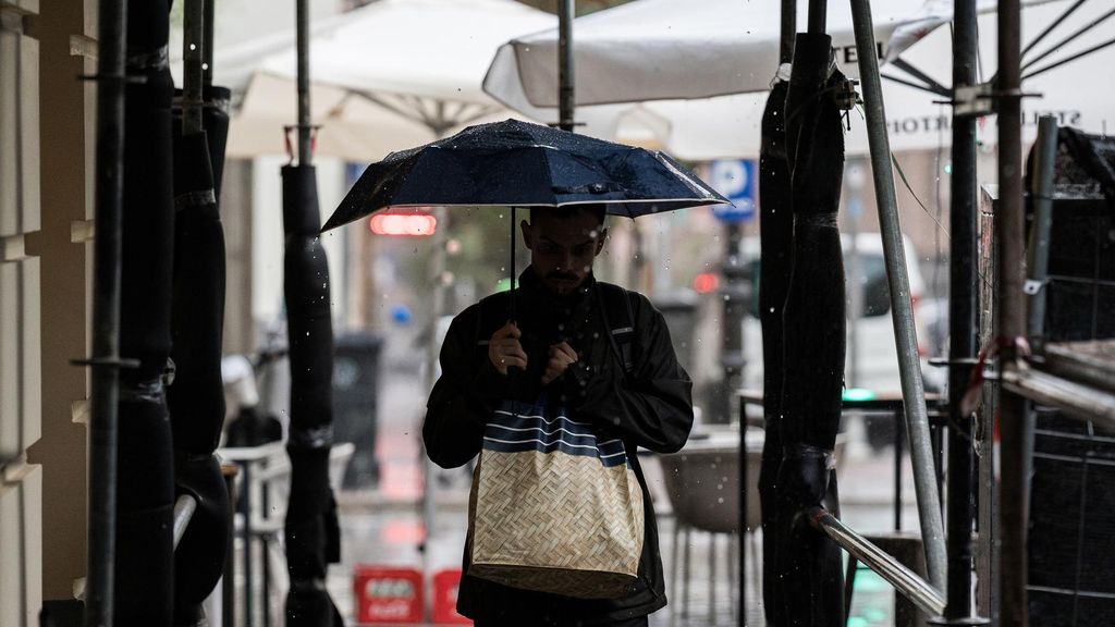 Archivo - Varias personas se resguardan de la lluvia con paraguas, a 3 de septiembre de 2023, en Madrid (España).