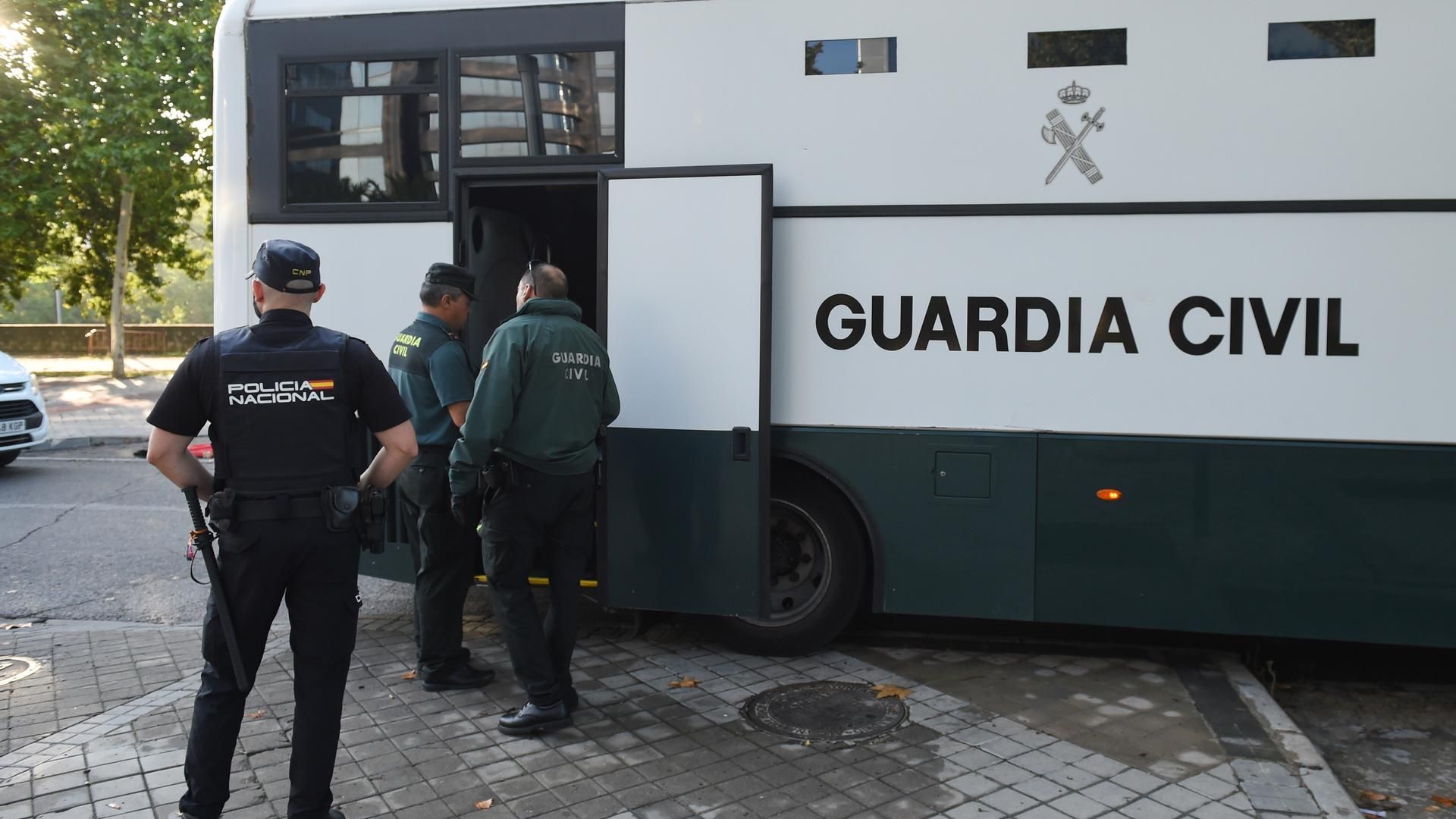 Archivo - Varios agentes de la Guardia Civil y de Policía Nacional junto a un autobús de la Guardia Civil frente a la Audiencia Provincial.