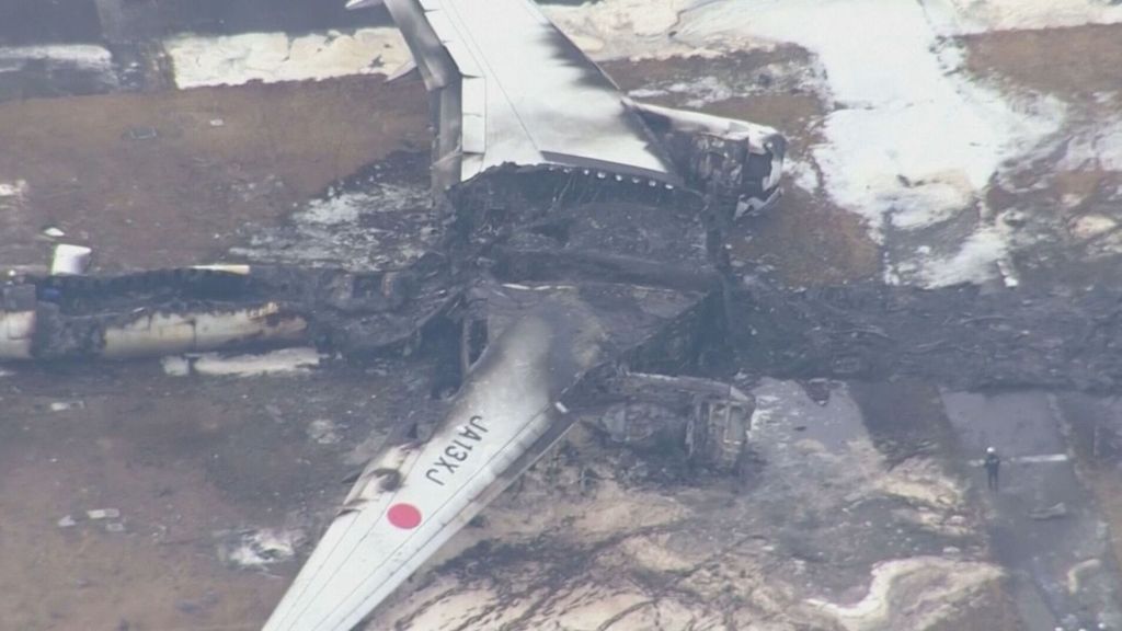 Restos calcinados del avión de Japan Arlines accidentado tras chocar con un aéreo militar en el aeropuerto de Tokio