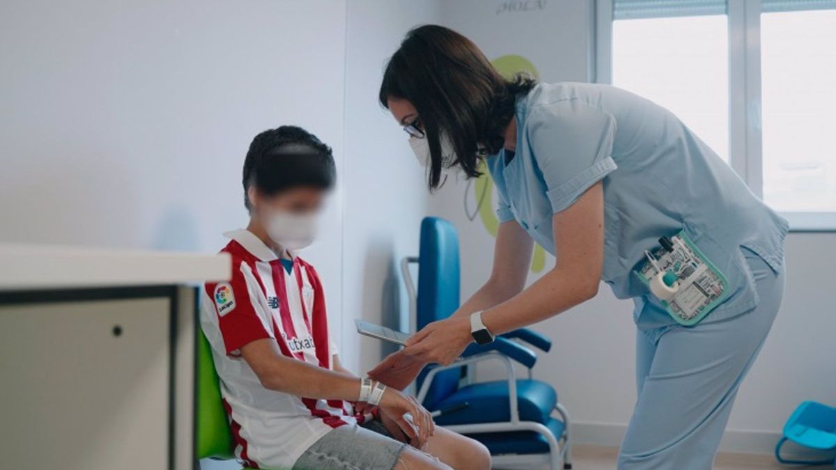 Una enfermera de pediatría atendiendo a un menor.